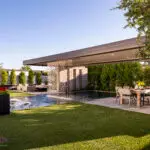Custom backyard design with large metal planters, metal shade structure and multiple seating areas.