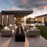 Custom backyard design with metal shade structure, outdoor dining area and artificial turf.