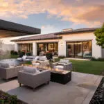 Custom backyard design with linear fire pit, black beach pebbles and multiple seating areas.