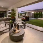 Custom backyard design with multiple seating areas, metal shade structure and rain curtain water feature.
