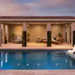 Custom backyard design with cabana, baja step and blue pool.