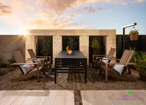 Custom backyard design with hanging plants, fire table and outdoor seating area.