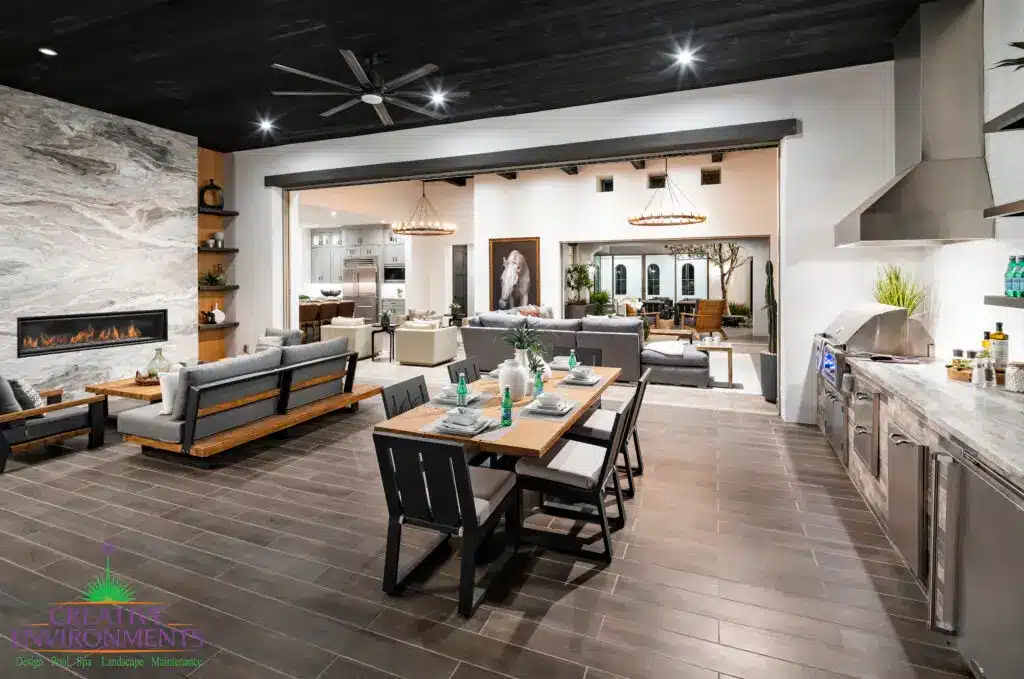Custom indoor/outdoor fusion with outdoor shelving, multiple seating areas and floor-to-ceiling marble fireplace.