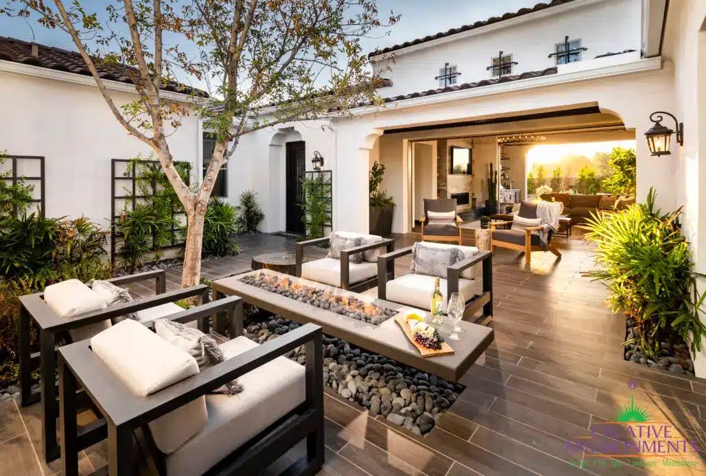 Custom entryway courtyard with fire table, metal trellis and multiple seating areas.