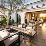 Custom entryway courtyard with fire table, metal trellis and multiple seating areas.