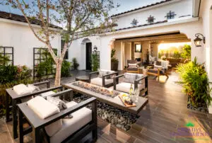 Custom entryway courtyard with fire table, metal trellis and multiple seating areas.
