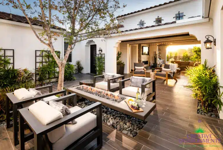 Custom entryway courtyard with fire table, metal trellis and multiple seating areas.