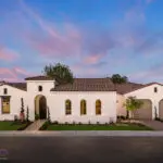 Custom front yard design with real grass, topiaries and mixed material driveway.