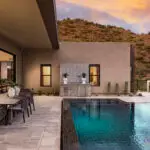 Custom backyard design with outdoor bar with deco-tile backsplash, multiple seating areas and pool.