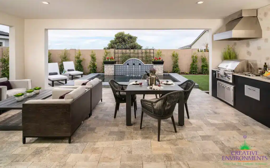 Custom backyard design with topiaries, outdoor kitchen and multiple seating areas.