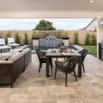 Custom backyard design with topiaries, outdoor kitchen and multiple seating areas.