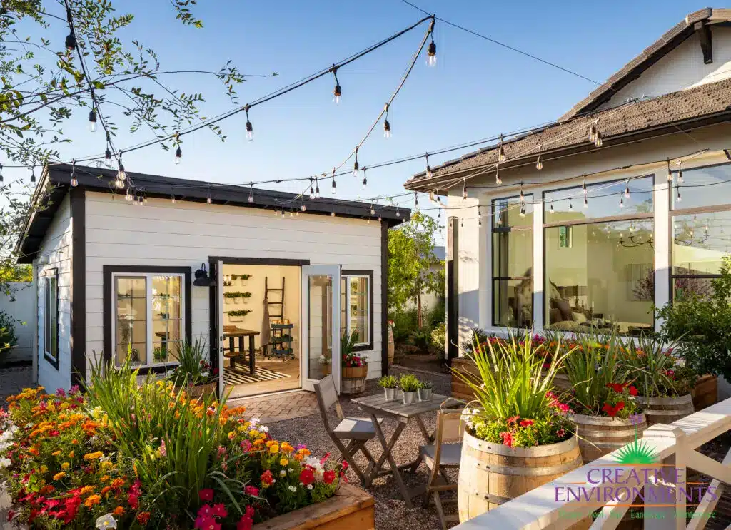 Custom backyard design with gardening area, string lighting and multiple planters.