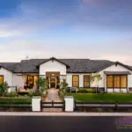 Custom front yard design with metal fencing, artificial turf and up lighting.