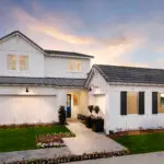 Front yard design with real grass, organized planting and metal planters.