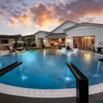 Backyard design with cantilevered wok fire pit, metal scupper water feature into blue pool and baja step.