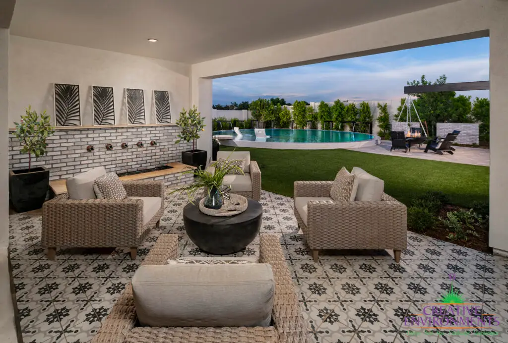 Custom backyard design with deco-tile patio, multiple seating areas and large metal planters.