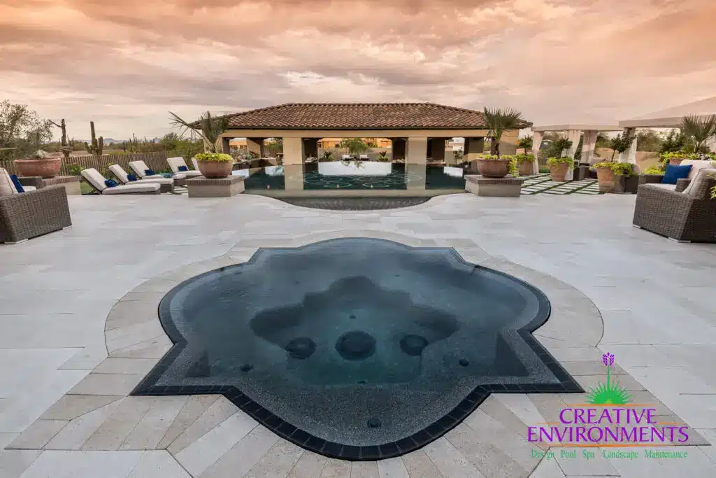Custom backyard design with artificial turf pattern, unique-shaped spa and large planters.