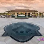 Custom backyard design with artificial turf pattern, unique-shaped spa and large planters.