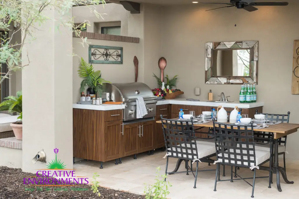 Custom backyard design with outdoor kitchen, outdoor dining area and planters.