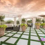 Custom backyard design with artificial turf pattern, cabanas and large planters.