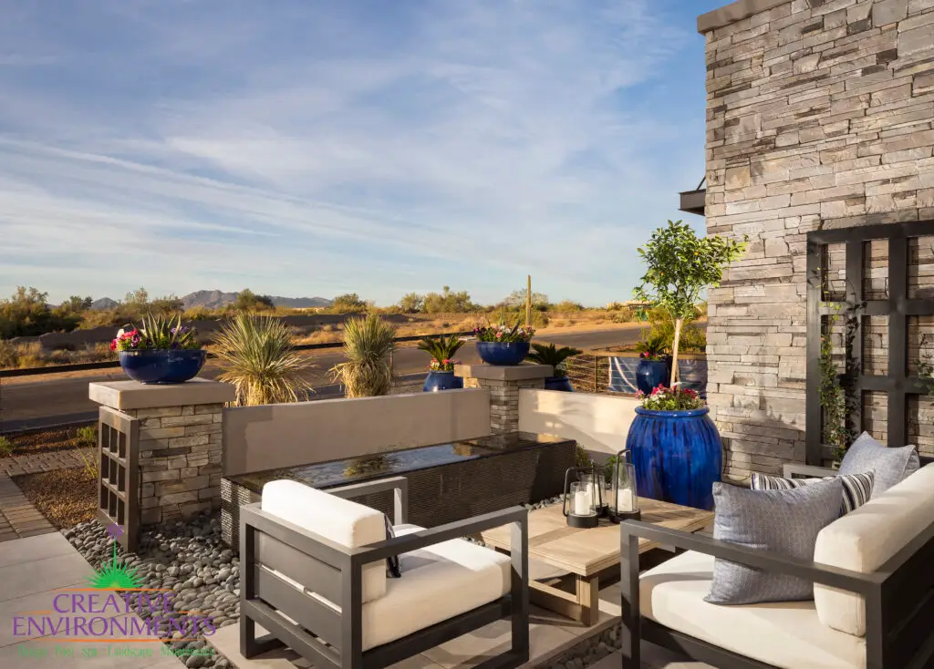 Custom courtyard design with water feature, metal trellis and outdoor seating area.