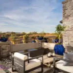Custom courtyard design with water feature, metal trellis and outdoor seating area.