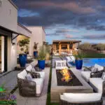 Custom backyard design with blue accents, shade structure and linear fire table.