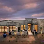 Custom front yard design with metal accents, up lighting and brick paver walkway and driveway.