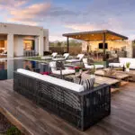 Custom backyard design with angled shade structure, multiple seating areas and zero-edge pool.