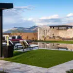 Custom backyard design with cantilevered outdoor shower, angled shade structure and artificial turf.