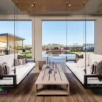 Custom backyard design with hanging seating, angled shade structure and zero-edge pool.