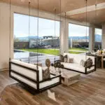 Custom backyard design with hanging seating, zero-edge pool and privacy wall surrounding hot tub.