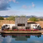 Custom backyard design with fireplace, raised seating area and zero-edge pool.