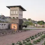 Custom community entrance with cantilevered planters, organized planting and metal scupper water feature.