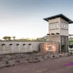 Custom community entrance with metal scupper water feature, unique entryway sign and cantilevered planters.