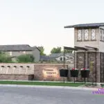 Custom community entrance with metal trellis, entryway sign and real grass.