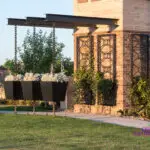 Custom community entrance with cantilevered shade structure, metal trellis and annuals.