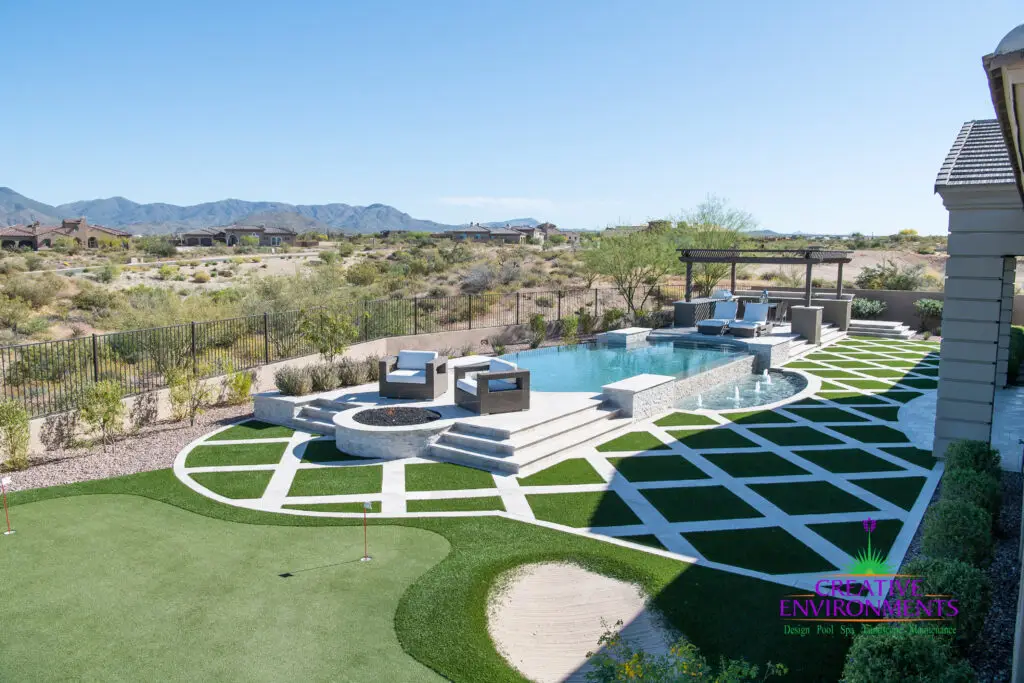 Custom backyard design with multiple seating areas, artificial turf pattern and putting green.