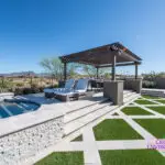 Custom backyard design with slatted shade structure, multiple seating areas and artificial turf pattern.