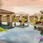 Custom backyard design with cabanas, zero-edge pool and large planters.