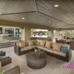 Custom backyard design with zero-edge pool, shade structure and multiple seating areas.