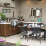 Custom backyard design with outdoor BBQ, outdoor dining area and organized planting.