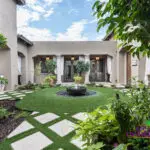 Custom courtyard design with water fountain, large planters and artificial turf pattern.