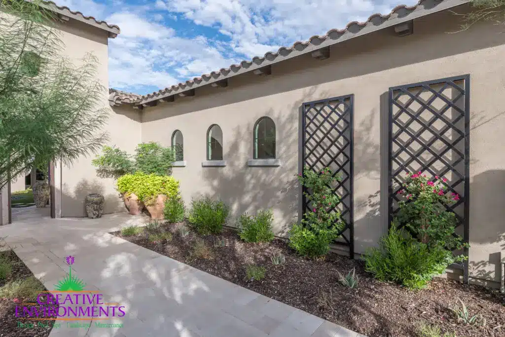Custom front yard design with metal trellis, large planters and natural stone pavers.