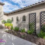 Custom front yard design with metal trellis, large planters and natural stone pavers.