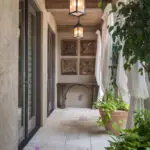 Custom indoor/outdoor design fusion with large planters, privacy curtains and black hanging lights.