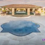 Custom backyard design with unique-shaped spa, zero-edge pool and multiple seating areas.