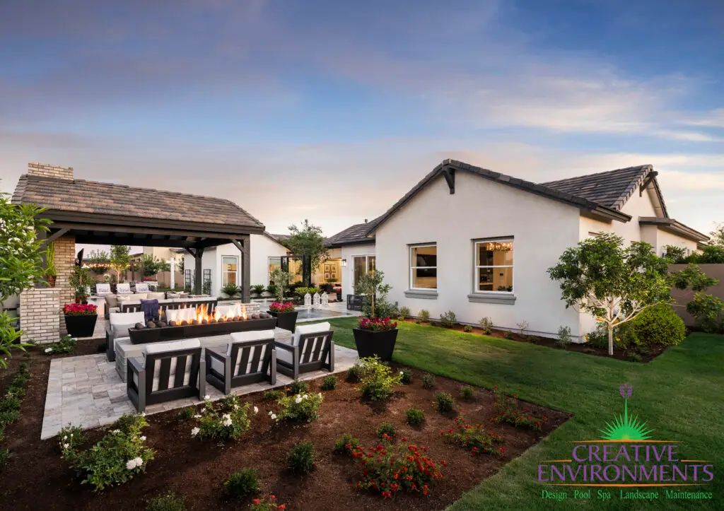 Custom backyard design with outdoor shade structure, fireplace and fire table.