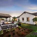 Custom backyard design with outdoor shade structure, fireplace and fire table.