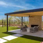 Custom backyard design with metal shade structure, string lights and artificial turf.